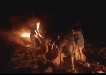 Warga gotong royong mengangkat sepeda motor yang melintas di ruas jalan yang tertimbun material longsor di Desa Liwulagang, Kecamatan Nagawutun, Selasa, 2 April 2024 malam.