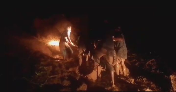 Warga gotong royong mengangkat sepeda motor yang melintas di ruas jalan yang tertimbun material longsor di Desa Liwulagang, Kecamatan Nagawutun, Selasa, 2 April 2024 malam.