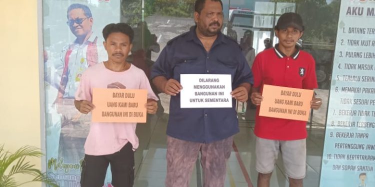 Abu Puen (tengah), Suplier yang menyediakan material pembangunan gedung Puskesmas Autaqnapoq bersama rekannya saat menyegel Puskesmas Autaqnapoq, Selasa, 16 April 2024.