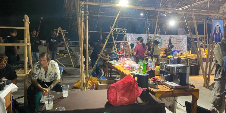 Stan UMKM peserta pameran Festival Lamaholot dari Flores Timur yang kursinya dirampas vendor dan disampingnya seorang bule duduk santai menikmati minuman, dan kursinya tak diambil vendor Festival Lamaholot di Pantai Wulenluo, Kota Lewoleba, Kabupaten Lembata.