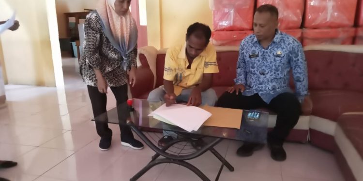 Salah satu ketua kelompok nelayan penerima bantuan coolbox aspirasi Bunda Julie Sutrisno Laiskodat menandatangani berita acara serah Terima bantuan disaksikan Kabid Penguatan Kapasitas Dinas Kelautan dan Perikanan Kabupaten Flores Timur.