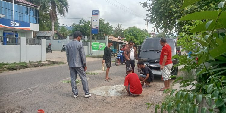 Para aktivis Taman Daun sedang gotong royong menambal jalan berlubang di depan BRI Unit Lewoleba, Rabu, 12 Maret 2025.