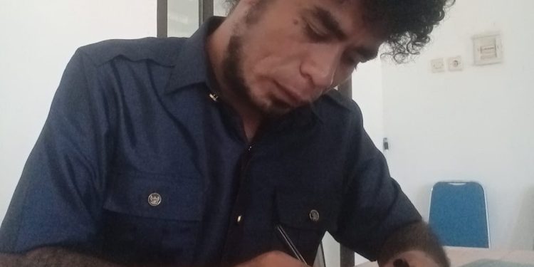 Jhon Batafor, anggota DPRD Lembata dari Fraksi Partai NasDem saat menandatangi surat yang akan disampaikan kepada Sekretaris DPRD untuk mengembalikan uang Bimtek yang sudah ditransfer ke rekeningnya.