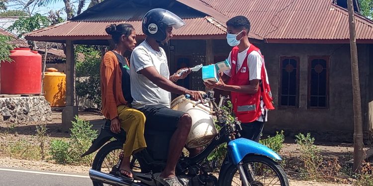 Bedos Making, jurnalis yang tergabung dalam Forum Jurnalis Lembata saat membagikan masker kepada warga di Desa Petuntawa, Lembata, Rabu, 13 Agustus 2025.