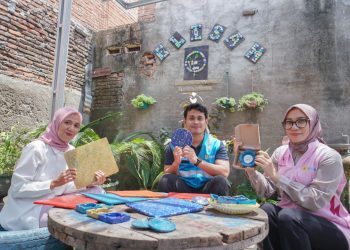Tim TJSL PLN UIP Nusra bersama pendiri Komunitas GELISAH, Lailatul Ulfah, memamerkan berbagai produk dari sampah botol plastik program bottle up.
