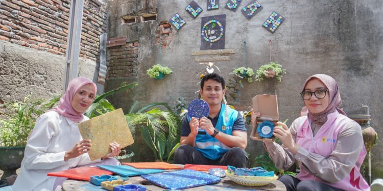 Tim TJSL PLN UIP Nusra bersama pendiri Komunitas GELISAH, Lailatul Ulfah, memamerkan berbagai produk dari sampah botol plastik program bottle up.