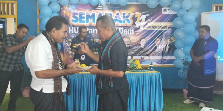 Ketua Dewan Pertimbangan DPD Partai NasDem Lembata Muhamad Nasir memotong tumpeng dan menyerahkannya kepada Lukas Lipatama Witak, perintis NasDem di Lembata. Tampak Muhamad Nasir menyuapi Lukas Lipatama Witak pada acara puncak HUT Partai NasDem di sekretariat DPD NasDem Lembata, Selasa, 11 November 2025.