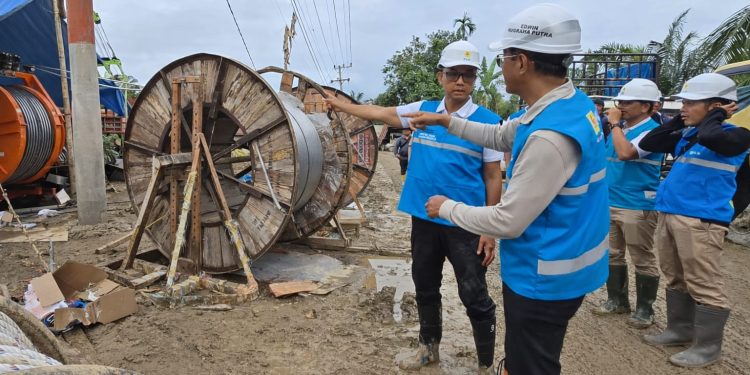 Direktur Utama PLN, Darmawan Prasodjo (kiri), Direktur Transmisi dan Perencanaan Sistem PLN, Edwin Nugraha Putra (kedua dari kiri) dan para petugas PLN ketika menyelesaikan pemasangan kabel di titik tower 142 pada jaringan transmisi Pangkalan Brandan - Langsa di Aceh Tamiang.