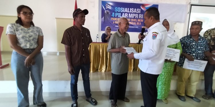 Wakil Bupati Lembata Muhamad Nasir yang juga Ketua Dewan Pertimbangan DPD Partai NasDem Lembata menyerahkan secara simbolis bantuan alat tangkap kepada nelayan Lamalera saat Sosialisasi 4 Pilar MPR RI di aula Perpustakaan Daerah Goris Keraf, Selasa, 17 Desember 2025.