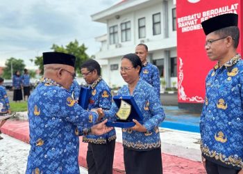 Bupati Lembata P Kanisius Tuaq menyerahkan piagam penghargaan Adiwiyata 2025 kepada 12 sekolah di Lembata saat apel kesadaran, Senin, 19 Januari 2026 di halaman kantor Bupati Lembata.