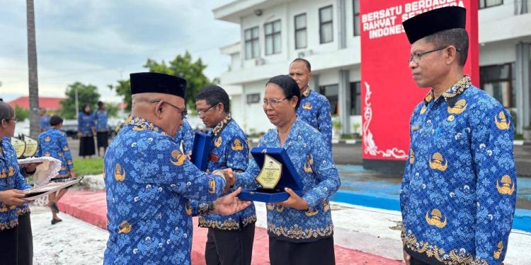 Bupati Lembata P Kanisius Tuaq menyerahkan piagam penghargaan Adiwiyata 2025 kepada 12 sekolah di Lembata saat apel kesadaran, Senin, 19 Januari 2026 di halaman kantor Bupati Lembata.