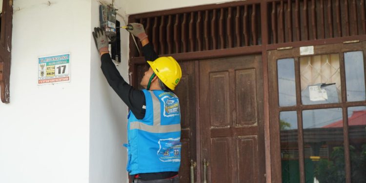 Ilustrasi petugas PLN saat melakukan penggantian _Miniature Circuit Breaker_ (MCB) pada kWh meter pelanggan yang melakukan tambah daya listrik.
